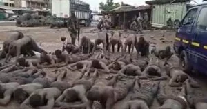 soldiers line up men at ashaiman in mud